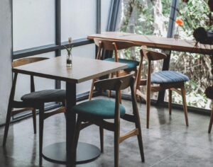 Inviting café interior with wooden furniture and large glass windows letting in natural light.
